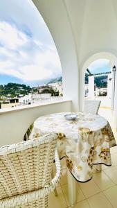 a white room with a table and chairs and a balcony at Villa La Zagara by CapriRooms in Capri