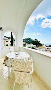 a white balcony with a table and two chairs at Villa La Zagara by CapriRooms in Capri