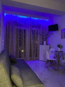 a purple bedroom with a bed and a table at Aggelikas apartments in Paleokastritsa