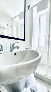 a white bathroom with a sink and a mirror at Villa La Zagara by CapriRooms in Capri