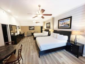 a bedroom with two beds and a dining room with a table at Catalina Courtyard Suites in Avalon