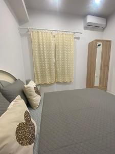 a bedroom with a bed and a window at Aggelikas apartments in Paleokastritsa +2 photos