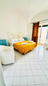 a bedroom with a bed with a yellow sheet on it at Villa La Zagara by CapriRooms in Capri