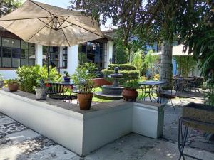 an outdoor seating area with a fountain and an umbrella at Hotel Boutique Casabella in Coatepec