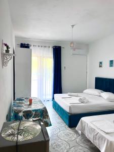 Habitación de hotel con 2 camas y ventana en Mabel Rooms, en Durrës