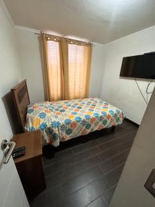 a small bedroom with a bed and a window at Departamento con vista al mar in Iquique