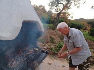 Ein Mann kocht Essen über einem Grill in der Unterkunft Agriturismo Cisogna in Anagni