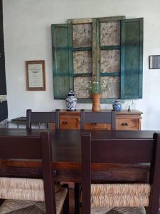 Hotel Boutique Casabella في كواتيبيك: غرفة طعام مع طاولة وكراسي خشبية