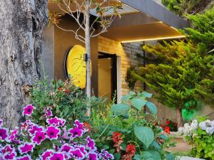 une maison avec des fleurs et une horloge sur la porte dans l'établissement Festim Villa Hotel, à Vlorë