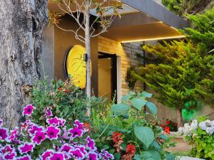 dom z kwiatami i zegarem na drzwiach w obiekcie Festim Villa Hotel we Wlorze