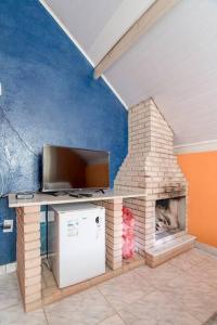 a living room with a tv and a fireplace at Chales Fazenda Cantinho do Selado in Monte Verde