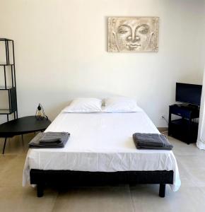 um quarto com uma cama grande e uma estátua na parede em Le studio du bonheur em Orange