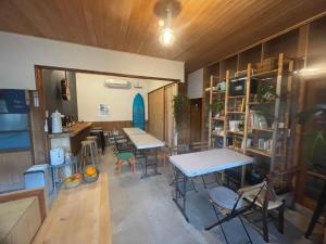 una habitación con mesas y sillas en アタシカデイズ Kumano Kodo Private Beach House, en Kumano