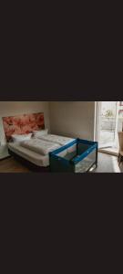 een bed met een blauw frame in een kamer met een raam bij Self CheckIn Hotel Heckenrose Lorin in Ringsheim