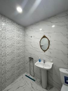 een witte badkamer met een wastafel en een spiegel bij Green house - Apartment 1g - 17 in Rustavi