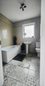 a bathroom with a tub and a toilet and a sink at The Bay house in Derry Londonderry