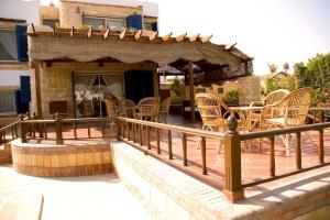 eine Terrasse mit Stühlen, einem Tisch und einem Backsteingebäude in der Unterkunft Sandorini Villa for Rent in Giza