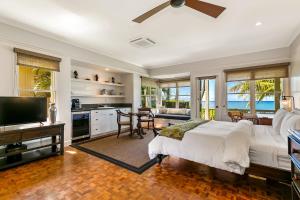 科洛阿的住宿－Classic 3br Oceanfront Cottage - Alekona Kauai，一间卧室配有一张床和一台电视,还设有一间厨房
