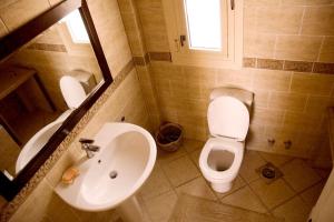 La salle de bains est pourvue de toilettes blanches et d'un lavabo. dans l'établissement Sandorini Villa for Rent, à Giza