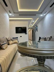 een woonkamer met een bank en een glazen tafel bij اقامة الانوار in Nador