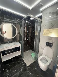 een badkamer met een toilet, een wastafel en een spiegel bij اقامة الانوار in Nador