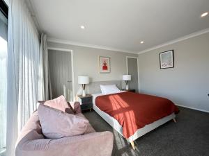 a bedroom with a bed and a couch at Mountain View Room in Wellington