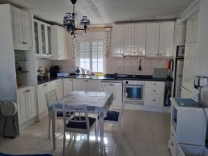 a kitchen with white cabinets and a table and chairs at Apartamento a 4 minutos andando de la playa in Dehesa de Campoamor