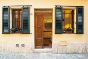 Casa con persianas azules y puerta de madera en Magione 10, en Siena