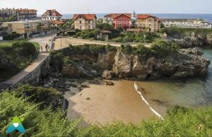 een uitzicht op een strand met huizen op een klif bij Viviendas Turísticas Los Cubos de Llanes 3 in Llanes
