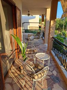 a patio with chairs and tables on a balcony at CASA Di TRE MARE in Nea Kallikrateia