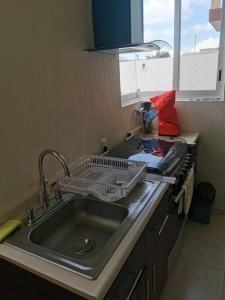um lavatório de cozinha com um suporte para secar pratos em Alquiler de Hermosa Casa sola con Piscina Privada em Los Limones
