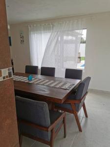 a dining room table with chairs and a table and a window at Alquiler de Hermosa Casa sola con Piscina Privada in Los Limones