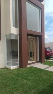 a building with glass windows on the side of it at Alquiler de Hermosa Casa sola con Piscina Privada in Los Limones