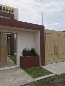 ein Gebäude mit zwei Garagentüren in einem Hof in der Unterkunft Alquiler de Hermosa Casa sola con Piscina Privada in Los Limones