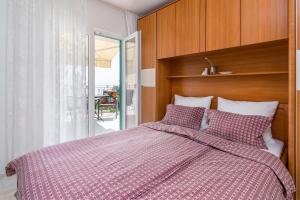 een slaapkamer met een bed met een rood en wit dekbed bij Apartments by the sea Medveja, Opatija - 7720 in Lovran