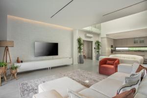 a living room with white furniture and a flat screen tv at Enclave Villa Luxury,Pool and Nature at Marmaris in Marmaris