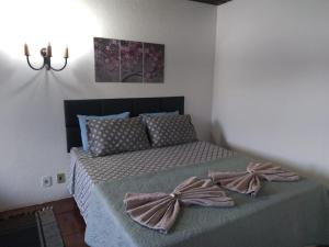 a bedroom with a bed with bows on it at Pousada Vênus in Monte Verde
