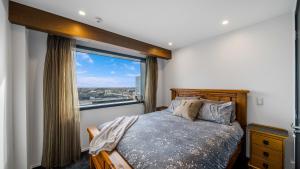 a bedroom with a bed and a large window at Central City View with Free Valet Parking in Christchurch