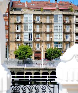duży budynek przed zbiornikiem wodnym w obiekcie Hotel Ripa w mieście Bilbao