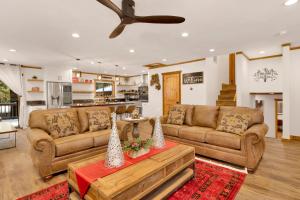 a living room with two brown couches and a table at Elmwood Place- Hot Tub- Packed Game Room in Big Bear City