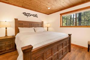 a bedroom with a large bed and a window at Elmwood Place- Hot Tub- Packed Game Room in Big Bear City +27 photos