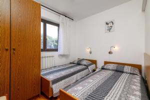 two beds in a room with a window at Apartments by the sea Banjole, Pula - 3002 in Pula