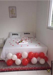 a bed with red and white balloons on it at Zaboca apartment in Roseau