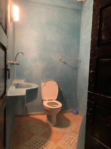 a bathroom with a white toilet and a sink at Nour Mogador in Ghazoua