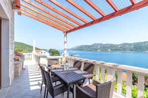 a balcony with a table and chairs and a view of the water at Apartments by the sea Tri Zala, Korcula - 4432 in Korčula