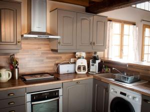 a kitchen with white cabinets and a counter top at Maison de campagne rénovée à 1h de Paris, avec jardin clos, 4 chambres et équipements familiaux - FR-1-590-164 in Treilles-en-Gâtinais