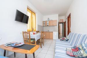 a living room with a couch and a table at Seaside holiday house Preko, Ugljan - 21106 in Poljana