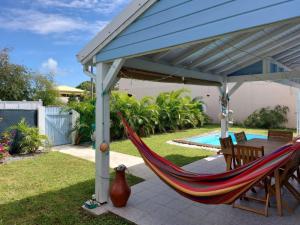a hammock under a pergola on a patio at Villa Créole -MARINA C0NCIERGERIE in Saint-François