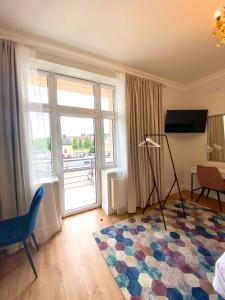 uma sala de estar com uma grande janela e um tapete em Apartamenty Pałacowe em Białystok