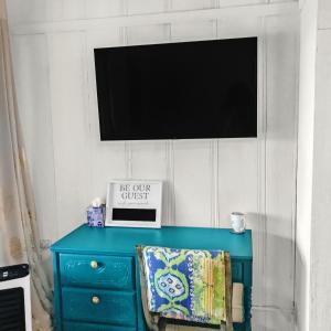 a blue dresser with a flat screen tv on a wall at George Gardens in Ramona